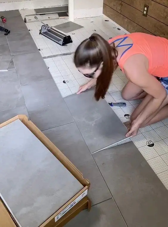 girl laying down tile flooring