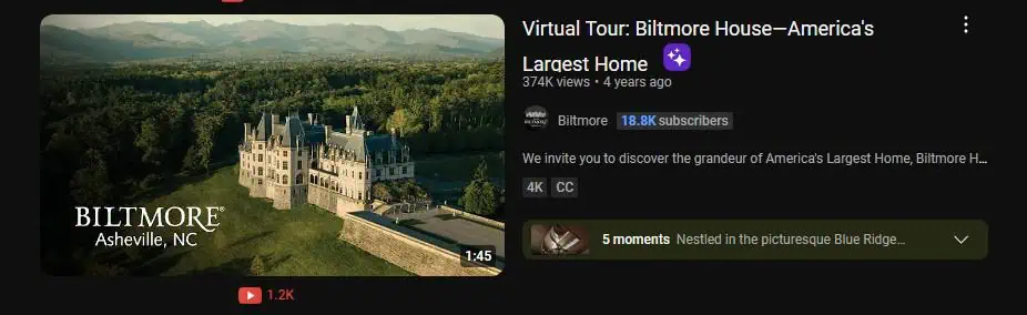 A YouTube video thumbnail showing an aerial view of the Biltmore House in Asheville, North Carolina, surrounded by lush greenery and mountains. The video title reads "Virtual Tour: Biltmore House—America’s Largest Home" by the channel Biltmore, which has 18.8K subscribers. The thumbnail emphasizes the grandeur of the estate, inviting viewers to take a virtual tour and learn about the history and architecture of America’s largest privately-owned home.